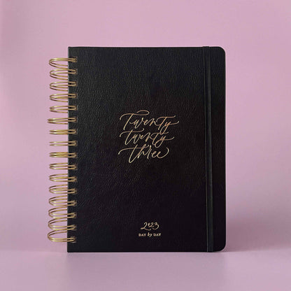 2023 daily planner with hard black vegan leather cover and a spandex closure