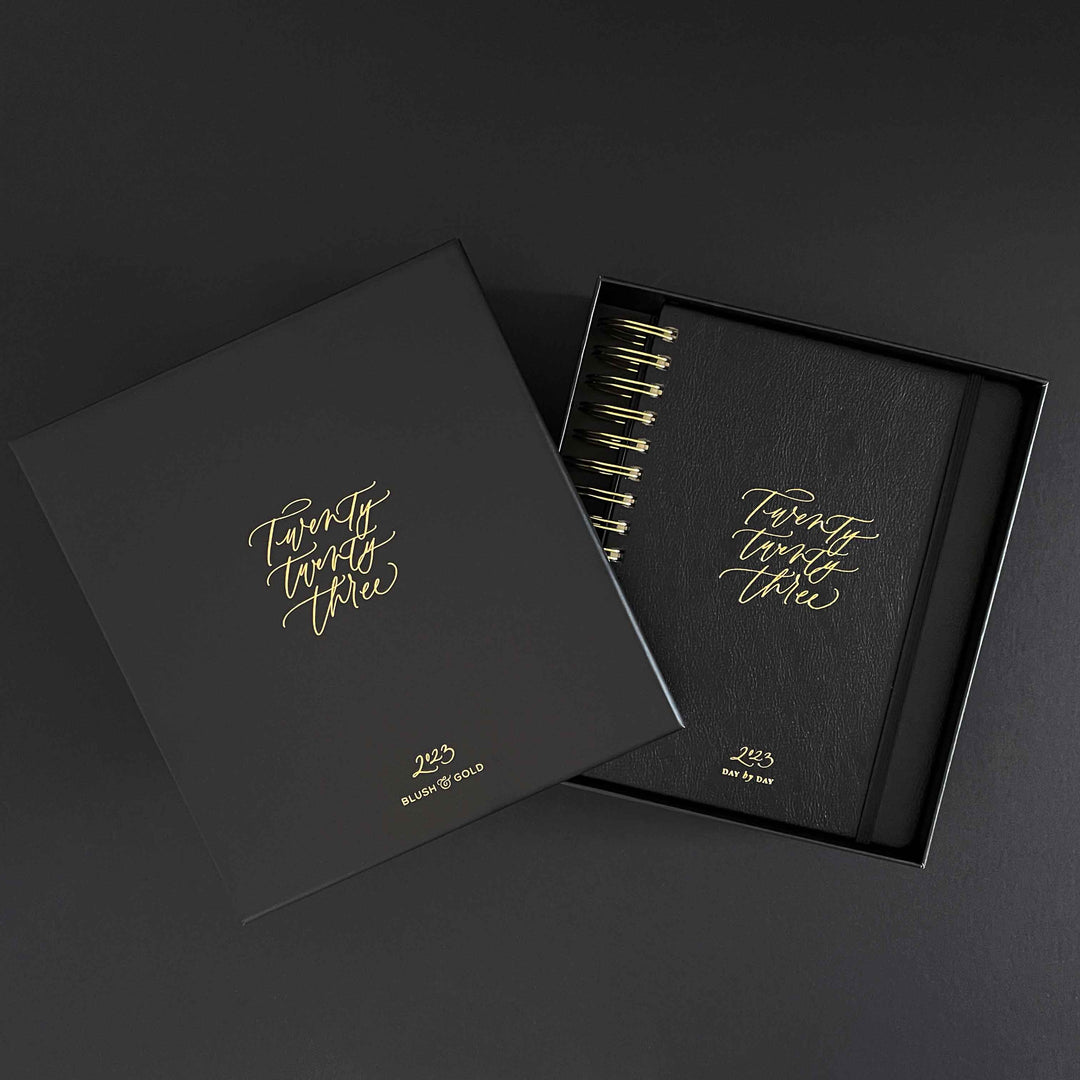 2023 vegan leather daily planner with gold edged pages and gold spiraling packaged in black gift. 