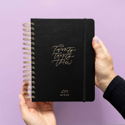hands holding the 2023 daily planner in black