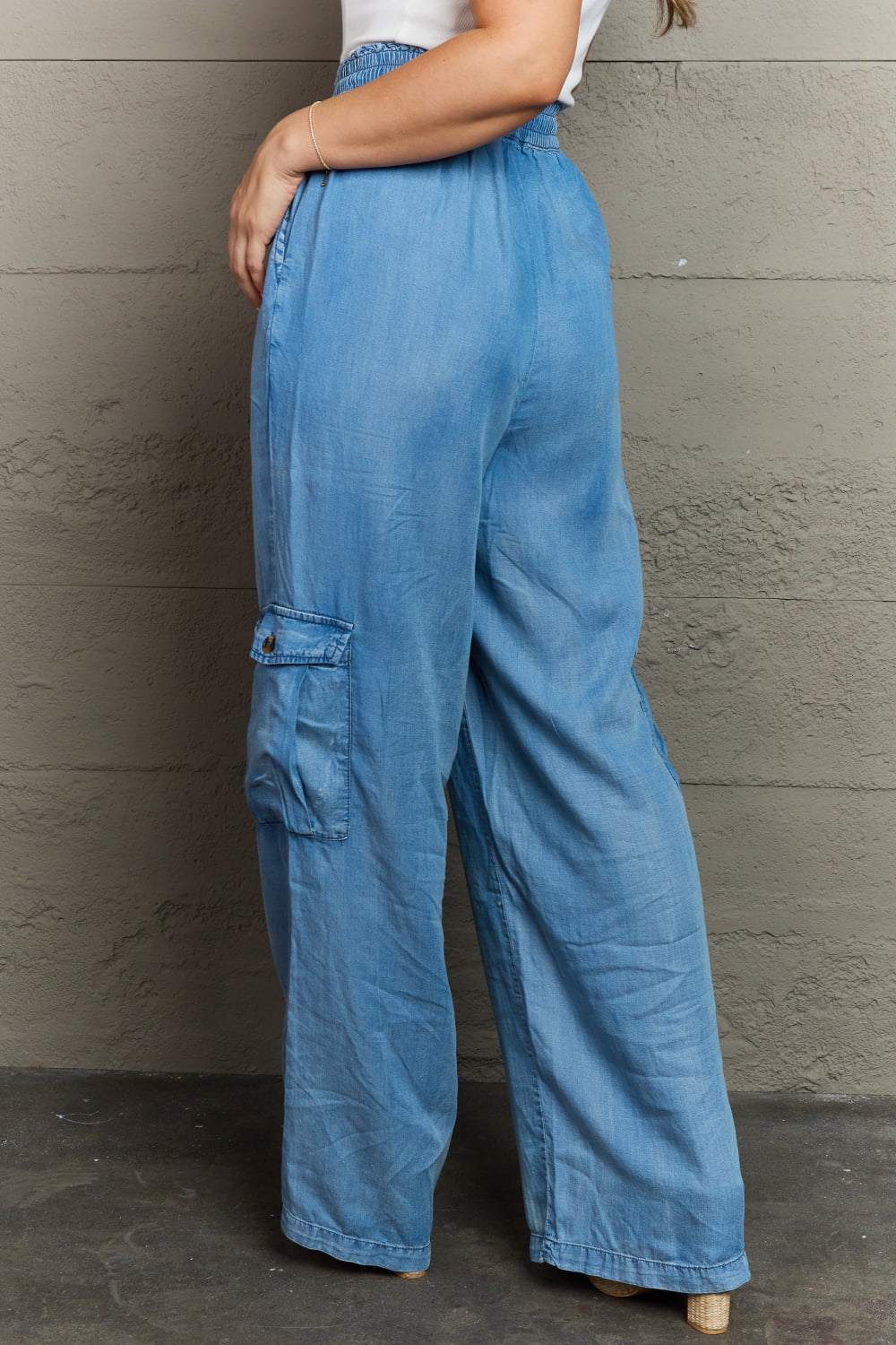 Stylish girl wears denim cargo pants: versatile, comfy, chic. 100% lyocell. Pockets. Care: Cold machine wash, low tumble dry
